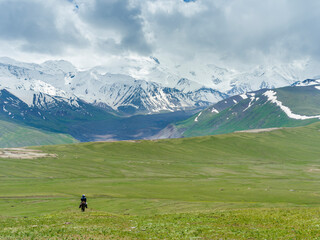 Fototapeta na wymiar Shepherd on donkey. Alaj Valley in front of the Trans-Alay mountain range in the Pamir Mountains. Central Asia, Kyrgyzstan