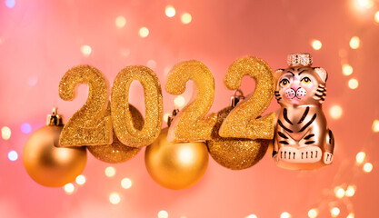 Tiger Christmas toy as the Symbol of year lunar chinese calendar on a greeting card. New Year Banner with golden Christmas balls.