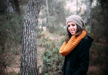 Mujer joven sonriendo durante el reportaje fotográfico en el bosque.  - obrazy, fototapety, plakaty