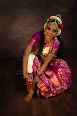 Bharatanatyam dancer putting on her khungru 