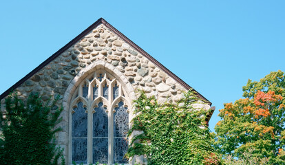 Fototapeta na wymiar A stone church wall with Gothic window 