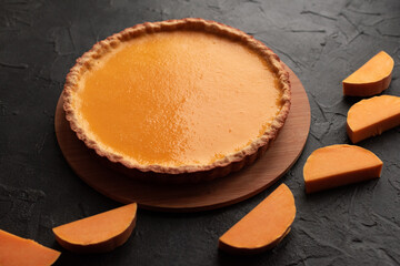 Pumpkin pie on dark background with squash slices