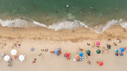 Fototapeta na wymiar Playa, sombrillas y gente en el mar. Top view.