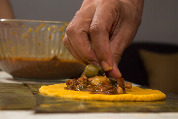 Traditional Venezuelan cuisine for the December festivities, hands preparing Hallacas. Typical dish of ancient traditions where a mixture of ingredients are wrapped in banana leaves