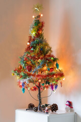 Decorated and lit Christmas tree at the corner of a room on top of furniture
