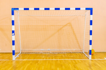 Football goal at a sports center, a sports hall with a wooden floor and a football sash. Selective...