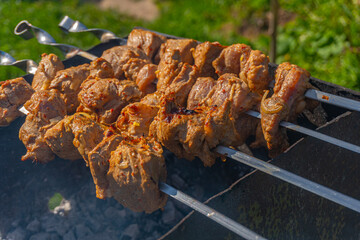 Grilled meat on skewers, fried kebabs on skewers on rusty brazier