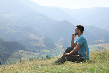 Naklejka na ściany i meble Man enjoying beautiful mountain landscape on sunny day