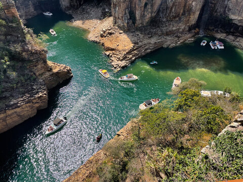 Canyon view from top, green water and some boats, high rock cliffs, sunny day in Capitolio MG Brasil - Lago de Furnas