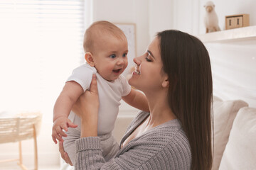 Happy young mother with her cute baby in living room