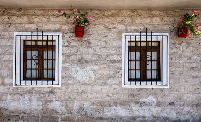 Two Barred Windows With Wooden Frames on a White Stone Wall in Arequipa Peru