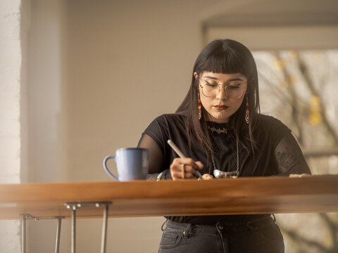Non binary Indigenous artist drawing indoors