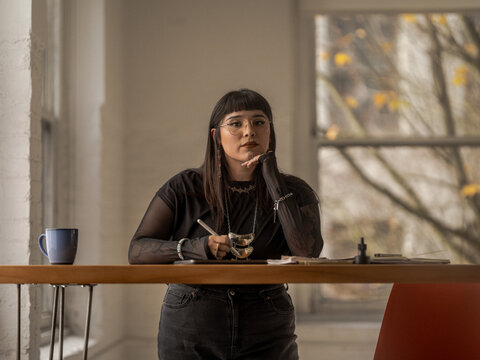 Non binary Indigenous artist drawing indoors