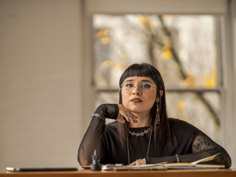 Non binary Indigenous artist drawing indoors