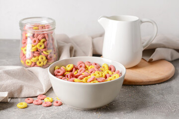 Bowl with crunchy corn flakes rings on grunge background
