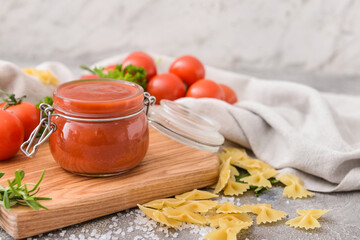 Jar with organic tomato sauce on grunge background