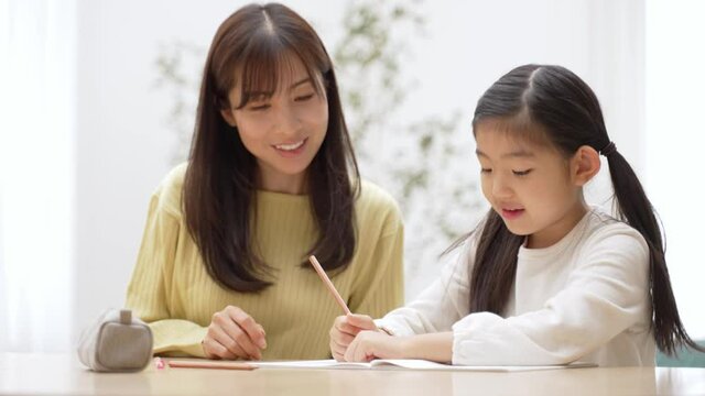 自宅で勉強をする女の子と教育ママ