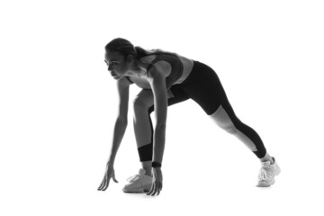 Silhouette of sporty young woman in crouch start position on white background
