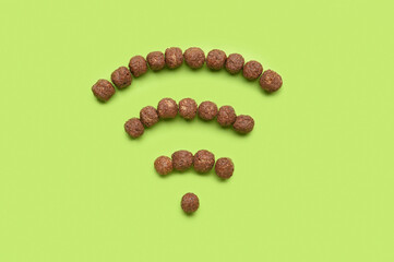 WiFi symbol made from chocolate balls on green background