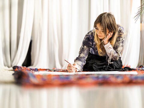 Young female Indigenous artist painting indoors