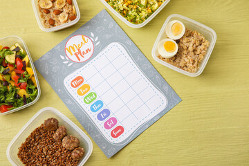 Containers with different healthy food and meal plan on color wooden background