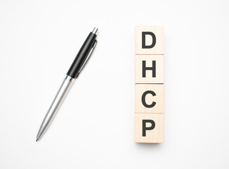 dhcp is made up of wooden cubes that stand on a burgundy notebook near the pen. Business concept