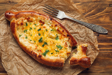 Tasty Ajarian khachapuri on table background