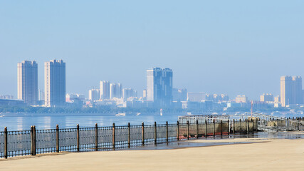 Obraz premium View from the promenade of the city of Blagoveshchensk, Russia to the city of Heihe, China during seasonal flood. Morning fog over the Amur River.