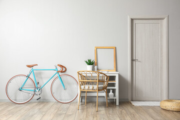 Modern workplace with frame and bicycle near light wall