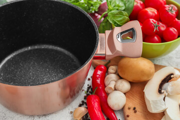 Cooking pot and ingredients for delicious soup on table, closeup