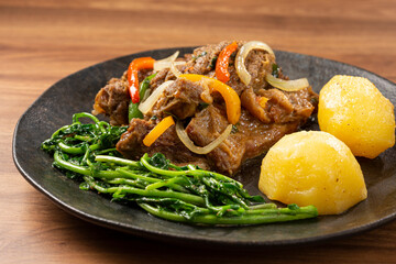 Cooked ribs with potatoes and watercress.