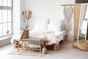 Interior of light bedroom with soft bench and dry reeds in vases - obrazy, fototapety, plakaty