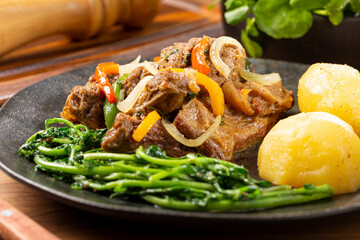 Cooked ribs with potatoes and watercress.