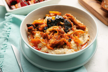 Bowl with delicious oatmeal, beef stew and prunes on table, closeup