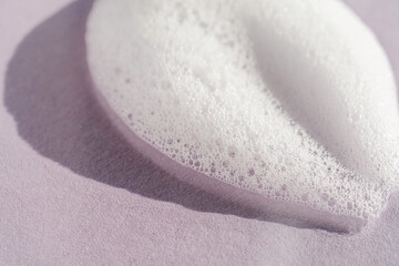 Texture of white foam on a purple background.