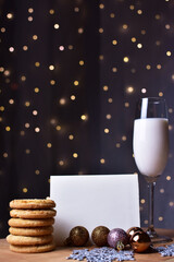 Christmas, cookie and milk with letter for santa claus, in front of the christmas lights