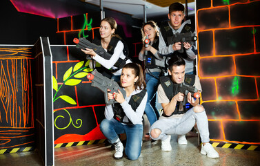 Fototapeta na wymiar Group glad people playing laser tag game. High quality photo