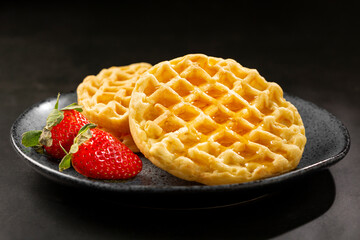 Delicious waffles. Plate with baked waffles on the table.