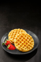 Delicious waffles. Plate with baked waffles on the table.