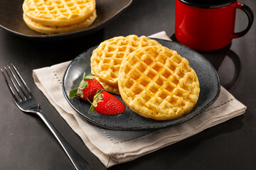 Delicious waffles. Plate with baked waffles on the table.