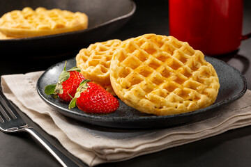 Delicious waffles. Plate with baked waffles on the table.