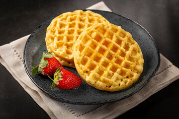 Delicious waffles. Plate with baked waffles on the table.