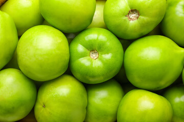 Green tomatoes as background, closeup