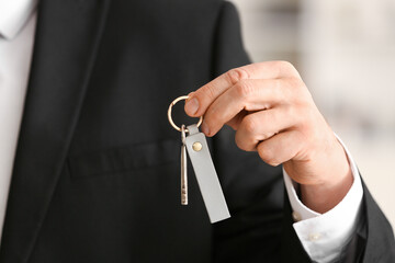 Man holding key on chain, closeup