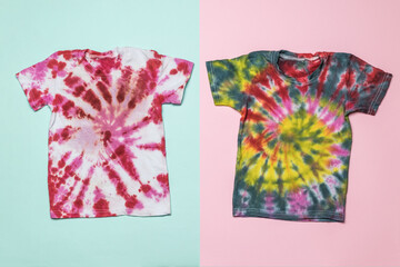 Two beautiful tie dye T-shirts on a two-tone background. Flat lay.