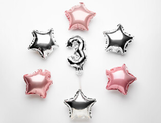 Figure 3 and different star shaped balloons on light background