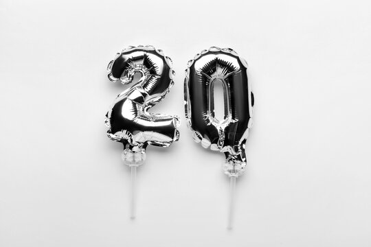 Figure 20 made of silver balloons on light background