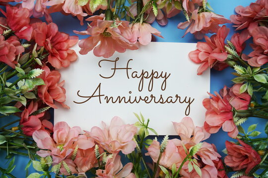 Happy Anniversary text with flower frame on blue background