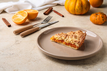 Plate with piece of fresh pumpkin pie on light background