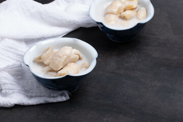 Banana in Coconut Milk , Thai Dessert (Kluay Buat Chi) on black background